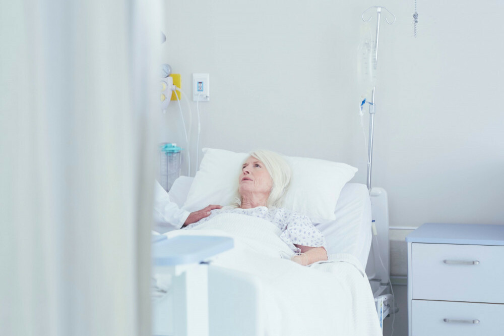 A doctor talking to female patient in hospital bed