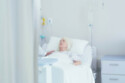A doctor talking to female patient in hospital bed