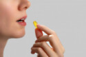 A woman taking a fish oil supplement
